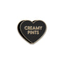 A heart-shaped enamel pin with a black face, gold border, and gold lettering that reads 'CREAMY PINTS' on a plain white background.