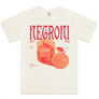 An off-white short-sleeve t-shirt featuring a vintage-style graphic print of a glass of red wine and a grapefruit, with the word 'NEGRONI' printed in large red letters across the chest.